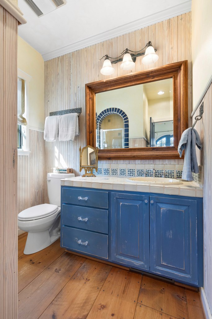 1129 Triple Creek Road Fredericksburg, TX 78624 - Photo 51 of 78 a bathroom with a toilet a sink and mirror