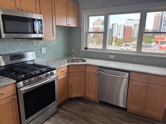 a kitchen with granite countertop a sink and a stove