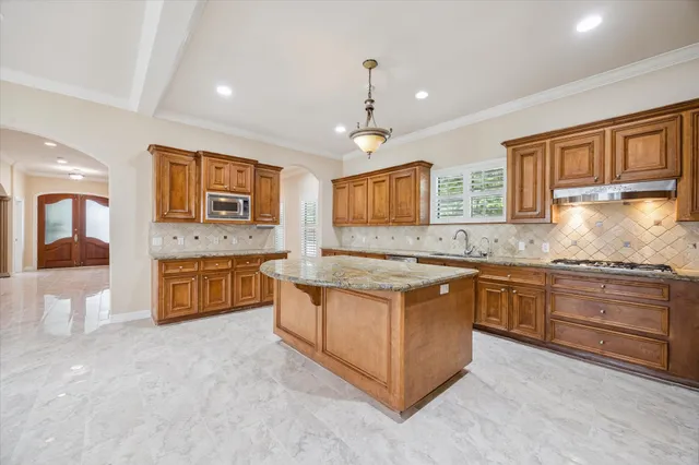 a large kitchen with stainless steel appliances granite countertop a stove and a sink