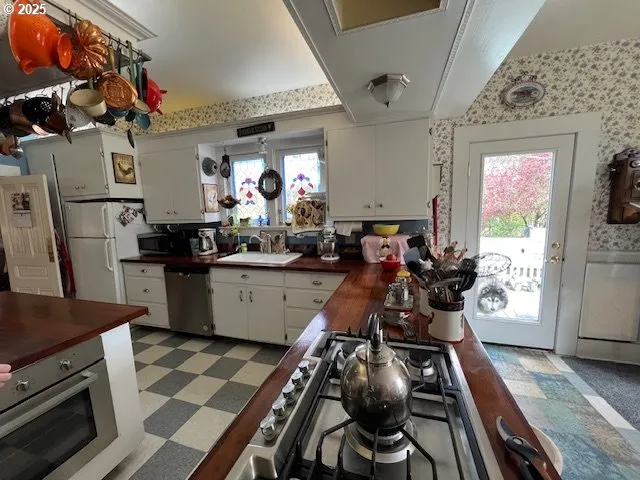 a view of a kitchen with appliances and furniture