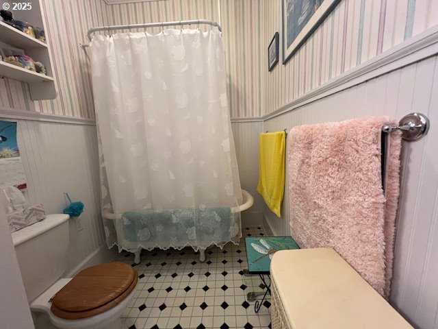 18 South Collier Street Coquille, OR 97423 - Photo 31 of 48 a bathroom with a toilet and a shower curtain