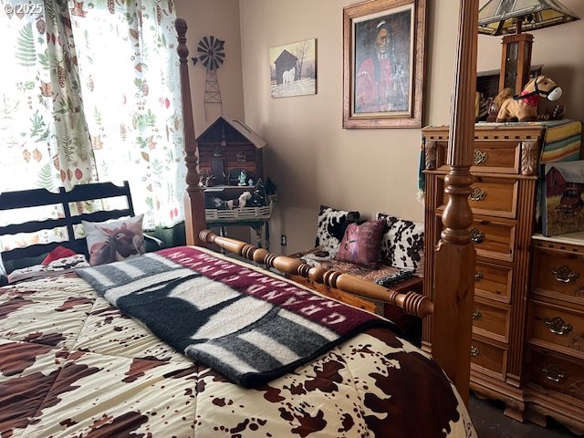 18 South Collier Street Coquille, OR 97423 - Photo 33 of 48 a bed sitting in a bedroom and chair next to a window