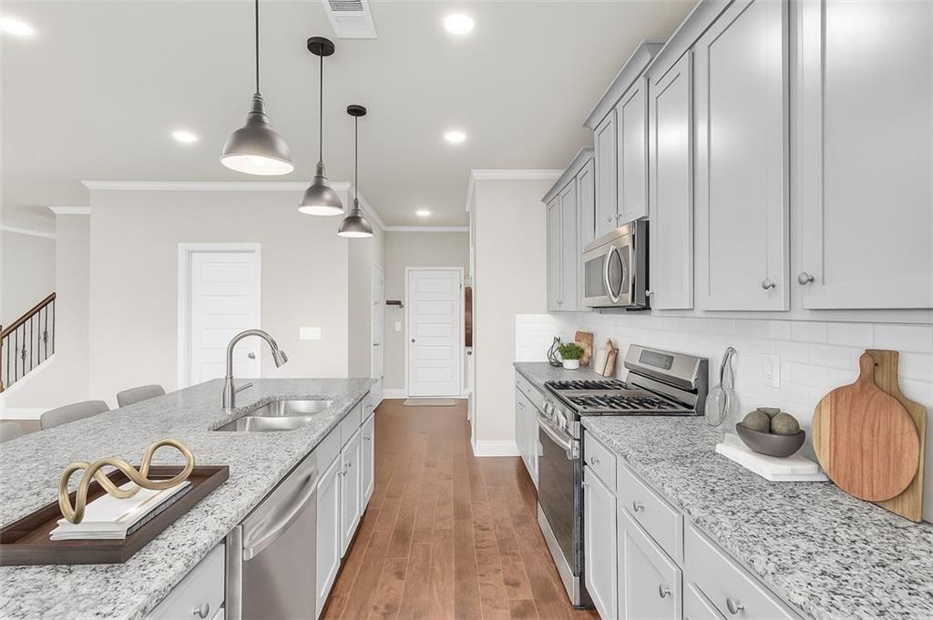 2340 Manor Pointe Drive Cumming, GA 30041 - Photo 14 of 45 a kitchen with granite countertop stainless steel appliances sink stove top oven and cabinets