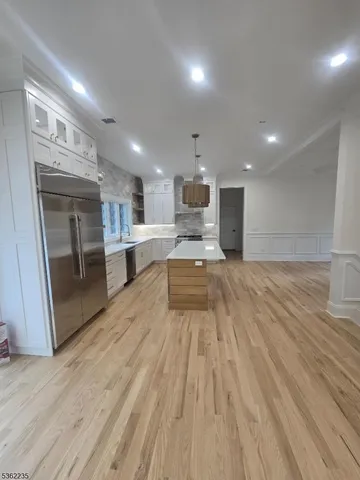 a view of kitchen with sink and refrigerator