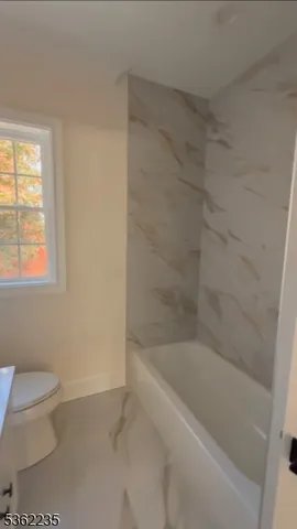 a bath room with a toilet and a bath tub