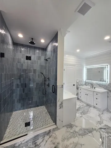 a bathroom with a bathtub shower sink and mirror