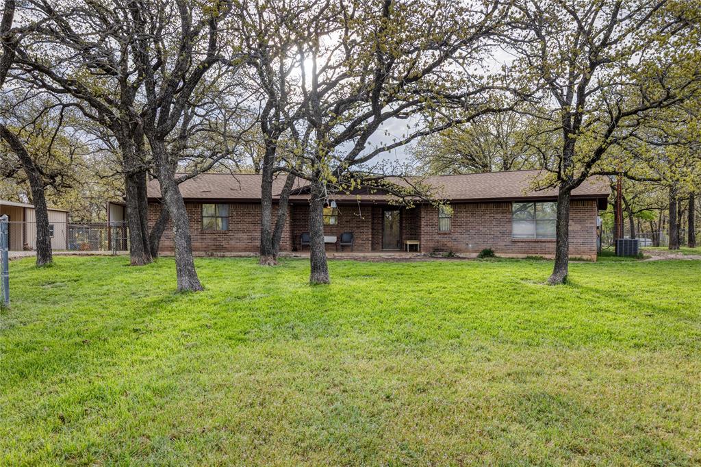 243 County Road 3851 Poolville, TX 76487 - Photo 1 of 34 a brick house with a big yard and large trees