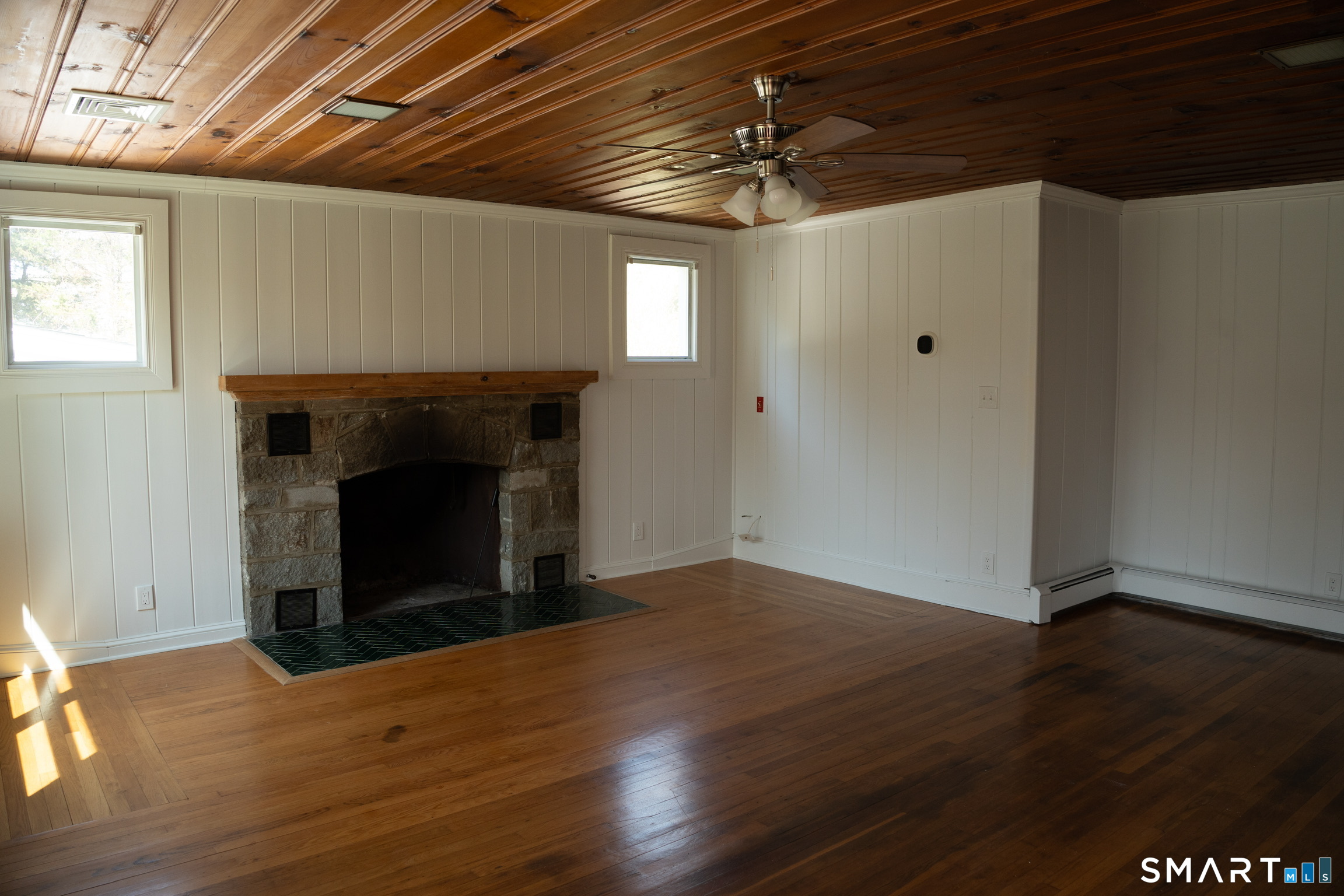 97 Candlewood Road Groton, CT 06340 - Photo 4 of 26 a view of an empty room with wooden floor a fireplace and a window
