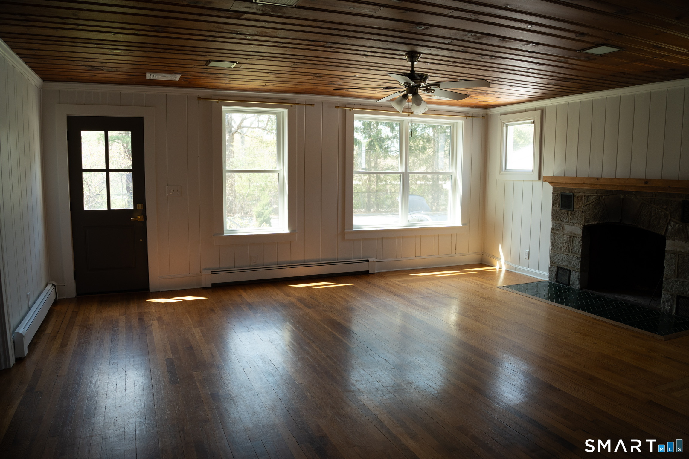 97 Candlewood Road Groton, CT 06340 - Photo 7 of 26 an empty room with wooden floor and windows