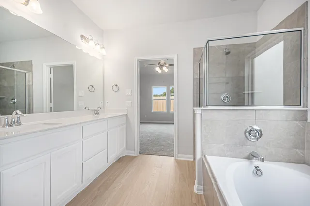 a spacious bathroom with a tub shower and sink