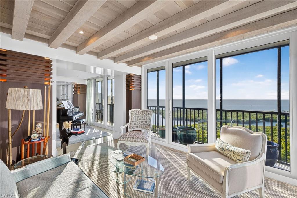 5601 Turtle Bay Drive, Unit 2104 Naples, FL 34108 - Photo 21 of 31 Sunroom / solarium featuring a water view, healthy amount of natural light, carpet flooring, a wooden ceiling with exposed beams, and floor to ceiling windows