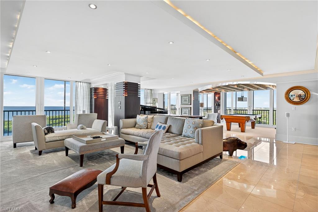 5601 Turtle Bay Drive, Unit 2104 Naples, FL 34108 - Photo 6 of 31 Living room with billiards table, a water view, floor to ceiling windows, light marble finish flooring, and recessed lighting