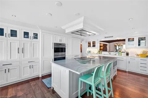 a view of kitchen island with stainless steel appliances granite countertop counter space and wooden floor