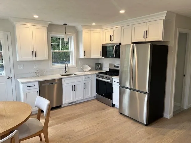a kitchen with stainless steel appliances a refrigerator stove microwave and sink