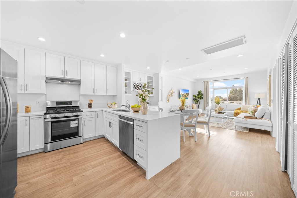 a kitchen with white cabinets and stainless steel appliances