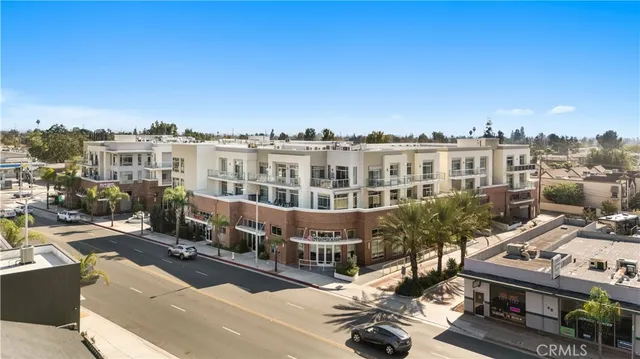 a view of a city that has tall buildings and cars parked