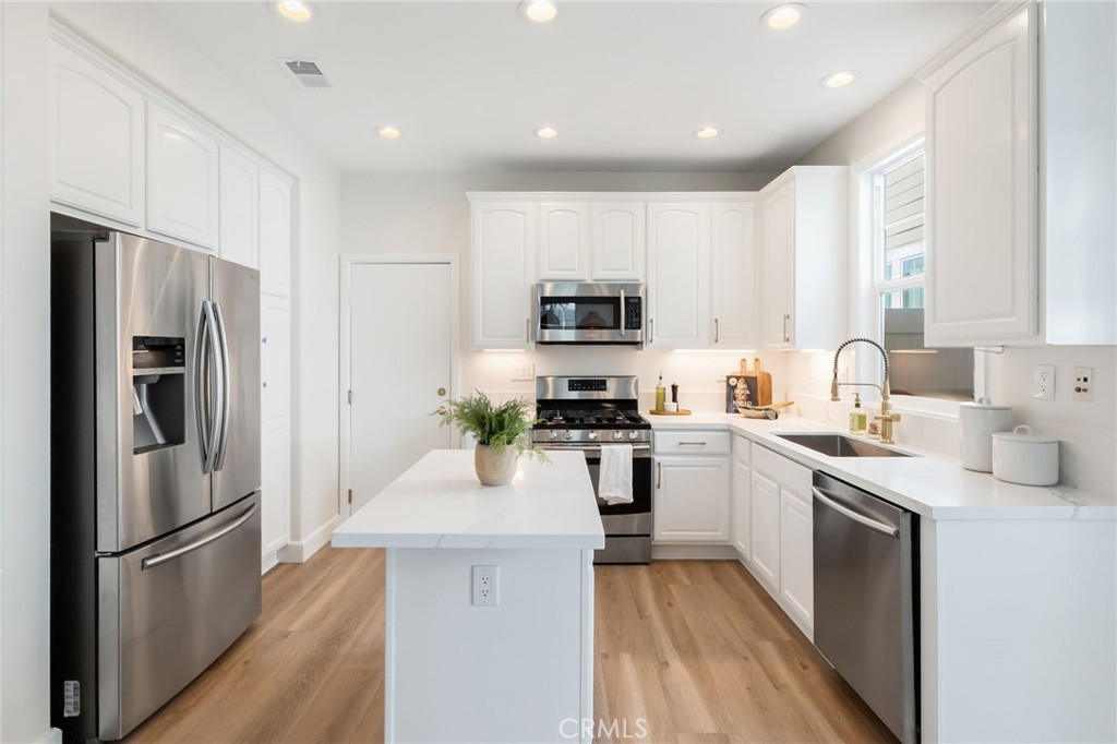 1 Tarleton Lane Ladera Ranch, CA 92694 - Photo 14 of 58 a kitchen with a refrigerator a sink and a stove top oven