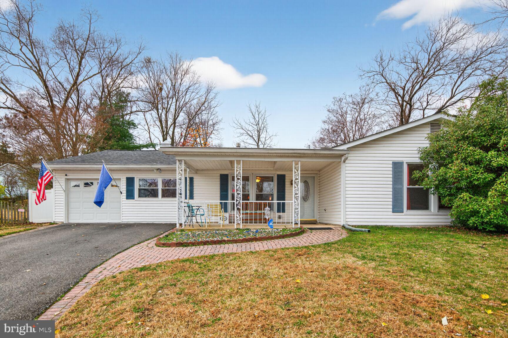 a front view of house with yard and trees in the background