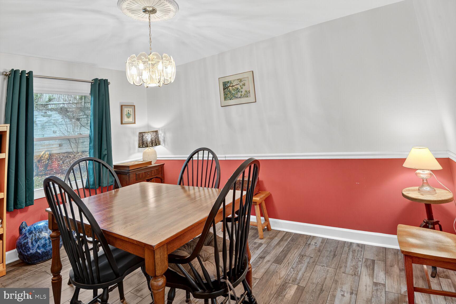 7908 South Cartier Court Severn, MD 21144 - Photo 12 of 27 a view of a dining room with furniture wooden floor and chandelier