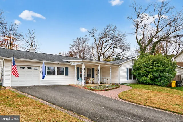 a view of a white house with a large tree
