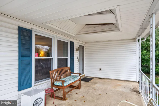 a view of patio with a table and chair and wooden fence