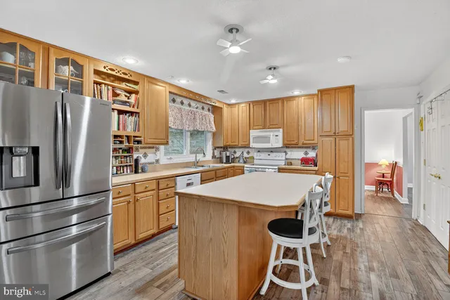 a kitchen with stainless steel appliances granite countertop a refrigerator a stove and a wooden floors
