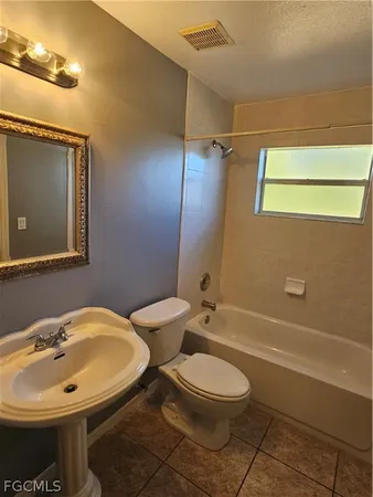 a view of an empty room and a chandelier fan