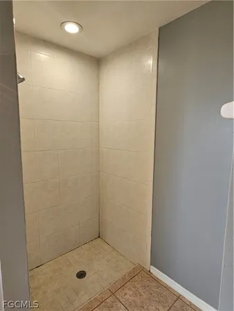 a view of an empty room with a chandelier fan