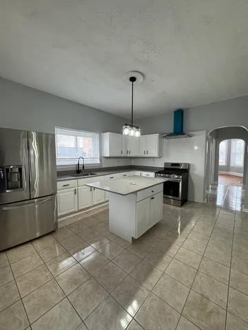 a large kitchen with stainless steel appliances granite countertop a stove a sink dishwasher and a refrigerator