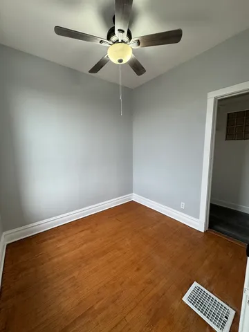 an empty room with a ceiling fan and a window