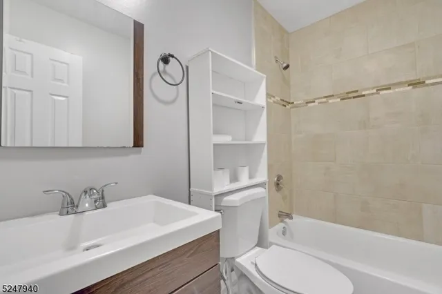 a bathroom with a sink toilet vanity and shower