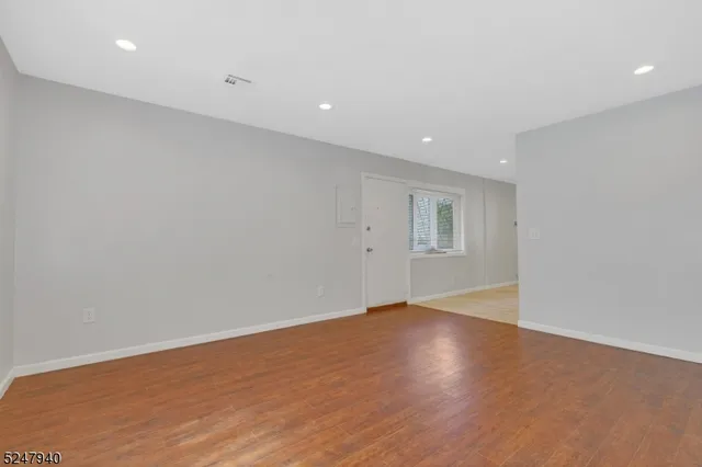 an empty room with wooden floor and white walls