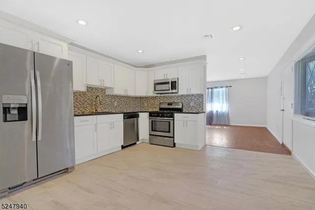 a kitchen with granite countertop a refrigerator and a sink