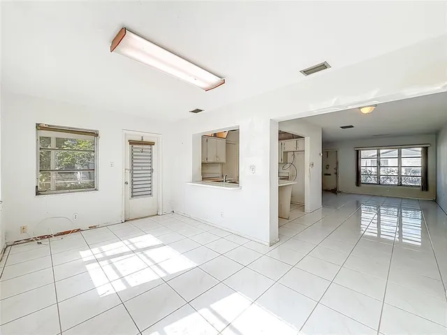 an empty room with closet and windows