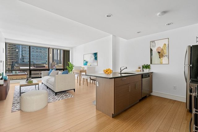 a view living room with stainless steel appliances kitchen island hardwood floor and living room view