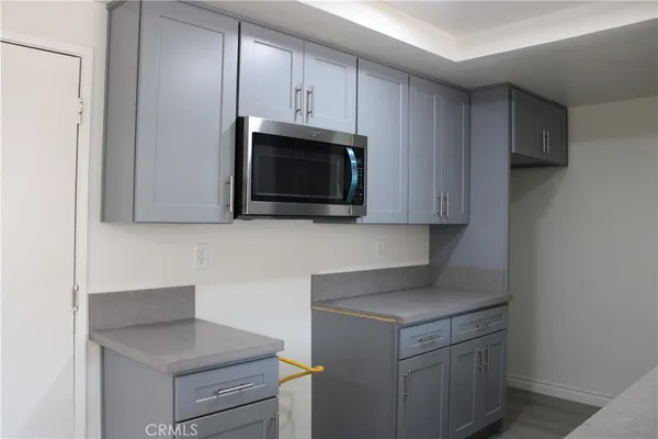 a kitchen with granite countertop cabinets stainless steel appliances and a counter space