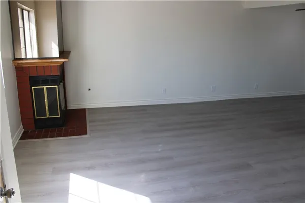a view of a livingroom with wooden floor and a large window