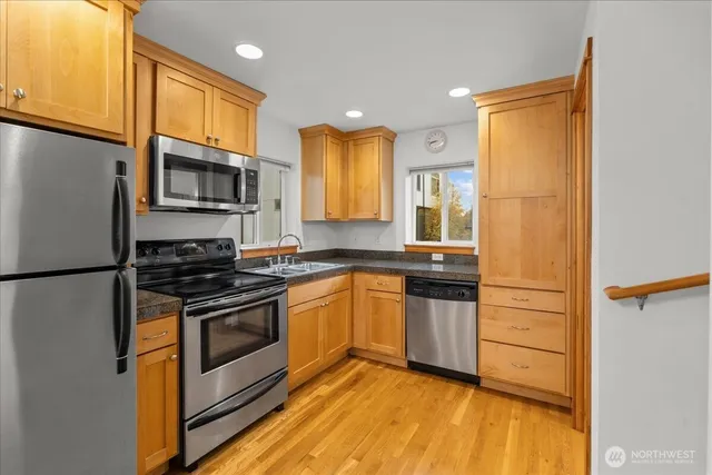 a kitchen with stainless steel appliances granite countertop a stove a refrigerator and a microwave