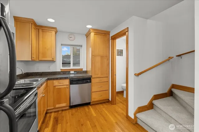 a kitchen with stainless steel appliances granite countertop a stove a sink and a refrigerator