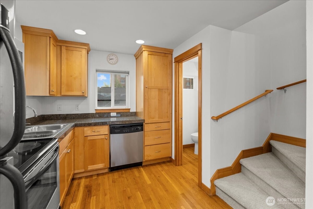 6348 34th Avenue Southwest, Unit C Seattle, WA 98126 - Photo 15 of 26 a kitchen with stainless steel appliances granite countertop a stove a sink and a refrigerator