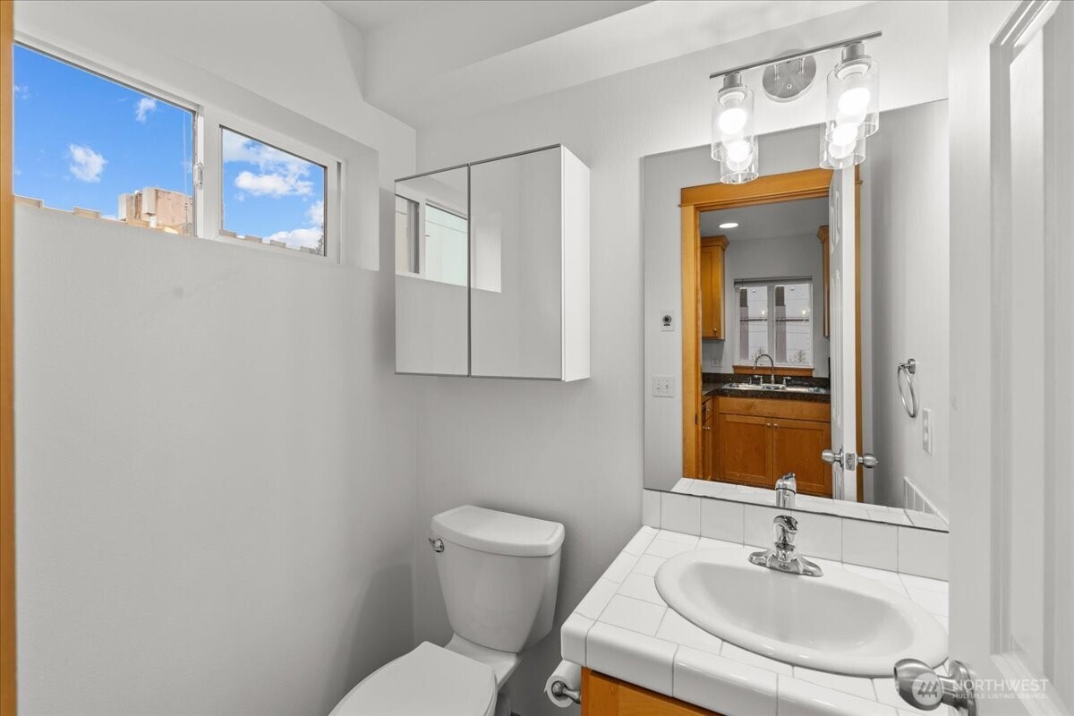 6348 34th Avenue Southwest, Unit C Seattle, WA 98126 - Photo 17 of 26 a bathroom with a sink toilet and mirror