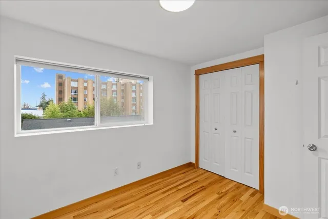 a view of empty room with window and wooden floor