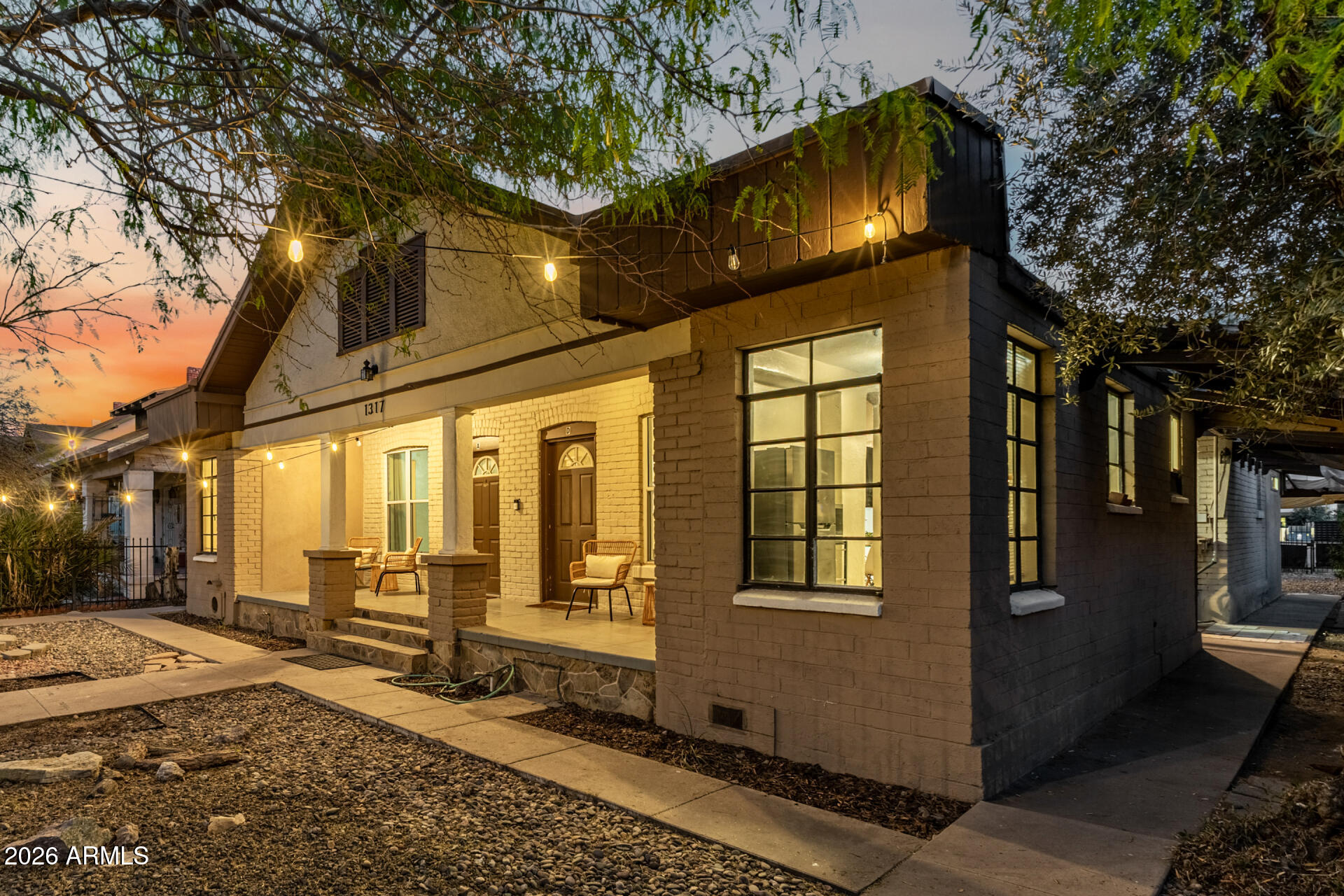 1317 West Monroe Street Phoenix, AZ 85007 - Photo 12 of 86 a view of a brick house with a large tree and many windows