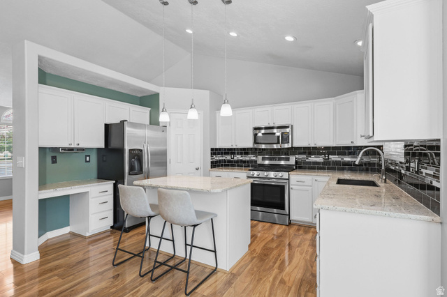 142 East 2675th Street South Clearfield, UT 84015 - Photo 10 of 49 Kitchen featuring white cabinetry, light-toned countertops, and a black subway tile backsplash