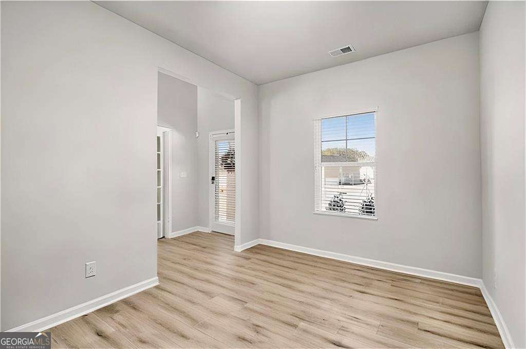 1101 Longleaf Trace Monroe, GA 30656 - Photo 11 of 36 a view of an empty room with wooden floor and a window