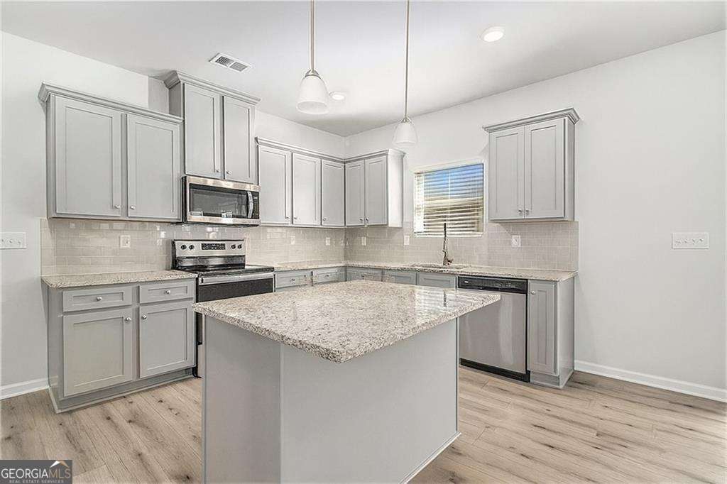 1101 Longleaf Trace Monroe, GA 30656 - Photo 13 of 36 a kitchen with stainless steel appliances granite countertop a sink stove and refrigerator