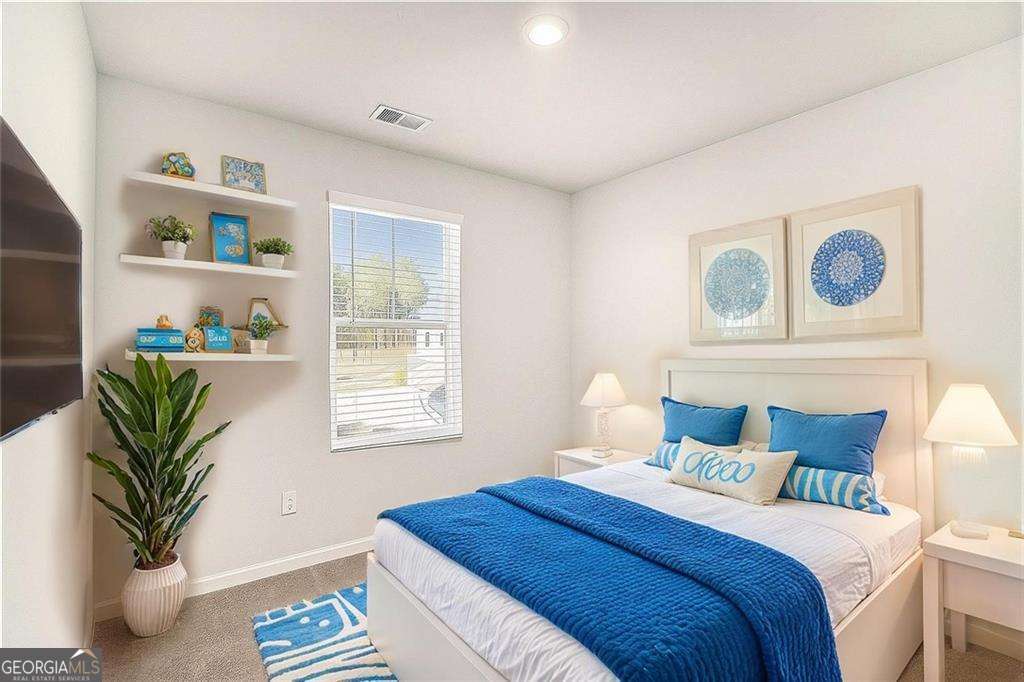 1101 Longleaf Trace Monroe, GA 30656 - Photo 29 of 36 a bedroom with bed and a potted plant