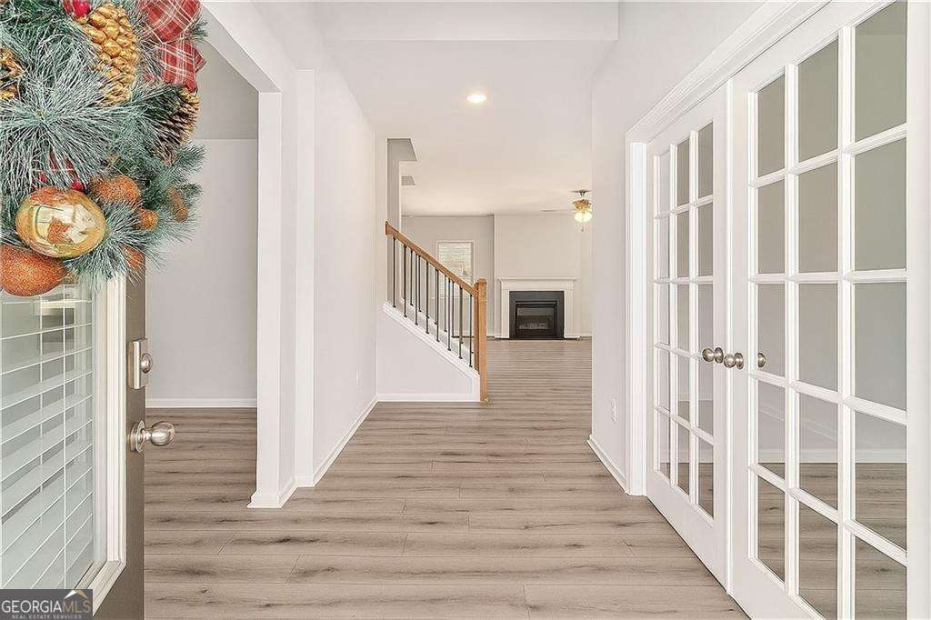 1101 Longleaf Trace Monroe, GA 30656 - Photo 5 of 36 a view of a hallway with wooden floor and staircase