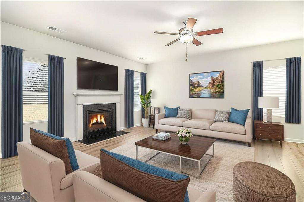 1101 Longleaf Trace Monroe, GA 30656 - Photo 8 of 36 a living room with furniture a fireplace and a flat screen tv