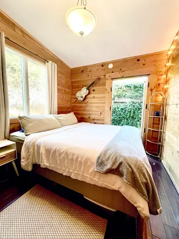 a bedroom with a bed and wooden floor